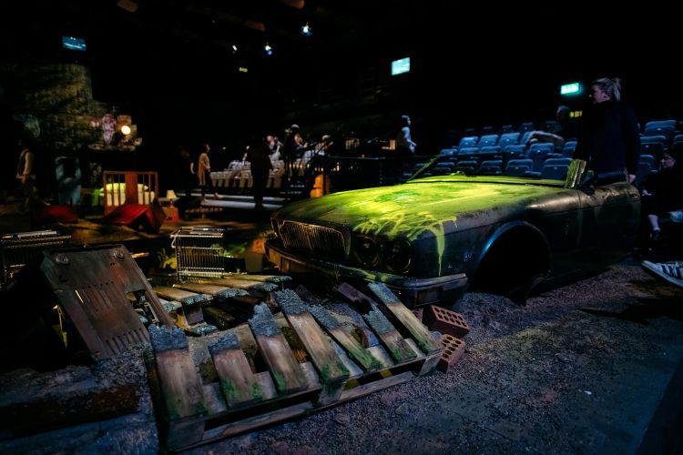 Empty set of The Angel Esmeralda with detritus and a ruined car painted green